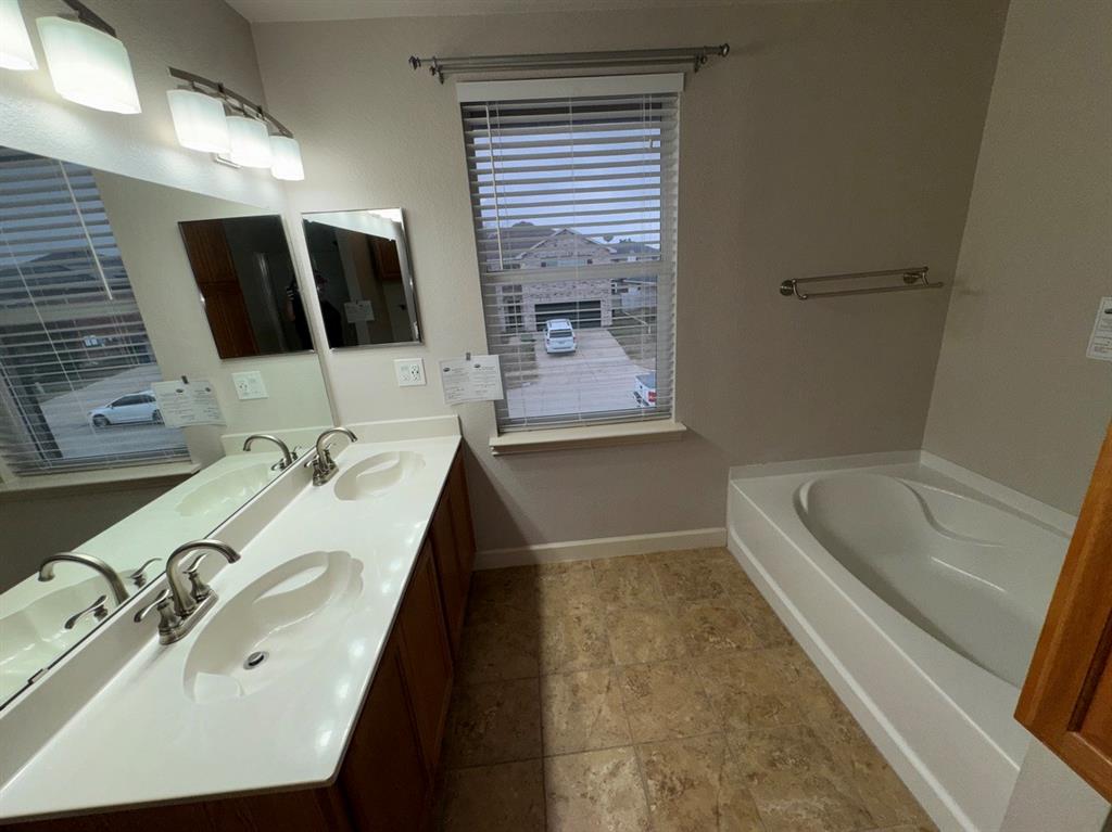 2024 Brazos Court Grand Prairie, TX 75052 - Photo 40 of 40 a bathroom with a tub a sink and mirror
