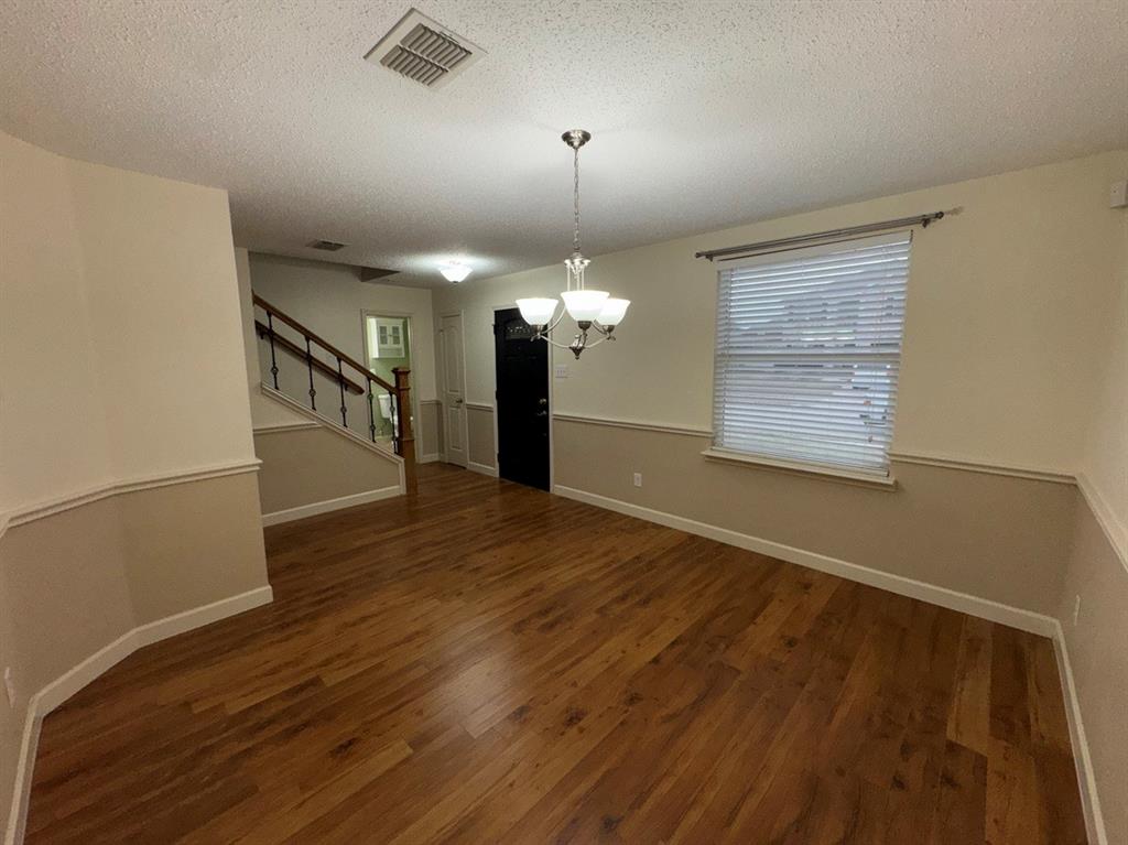 2024 Brazos Court Grand Prairie, TX 75052 - Photo 7 of 40 an empty room with wooden floor chandelier and windows