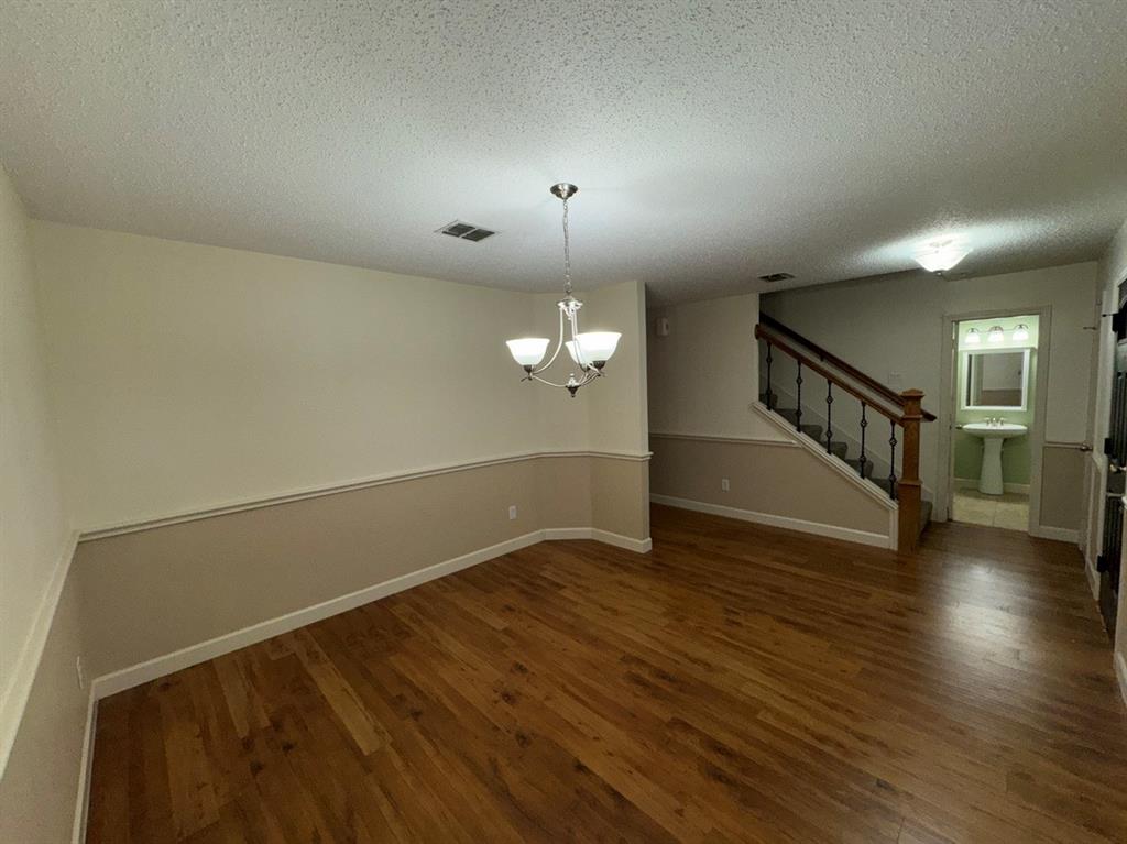 2024 Brazos Court Grand Prairie, TX 75052 - Photo 8 of 40 an empty room with wooden floor chandelier and windows