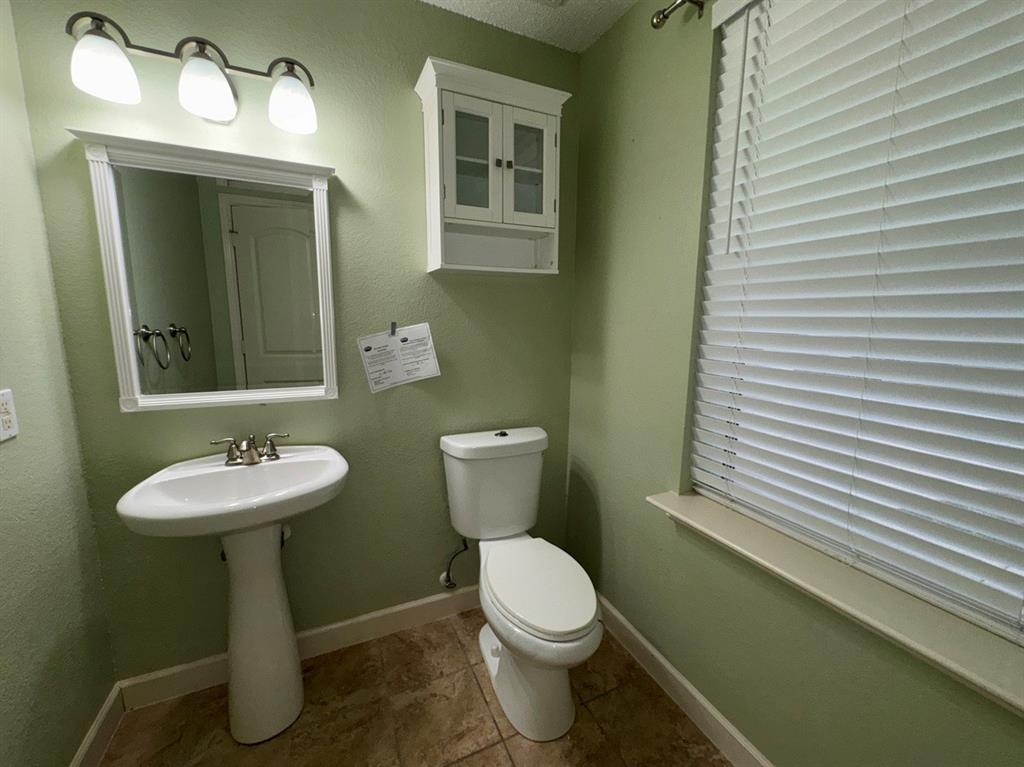 2024 Brazos Court Grand Prairie, TX 75052 - Photo 9 of 40 a bathroom with a toilet sink and mirror