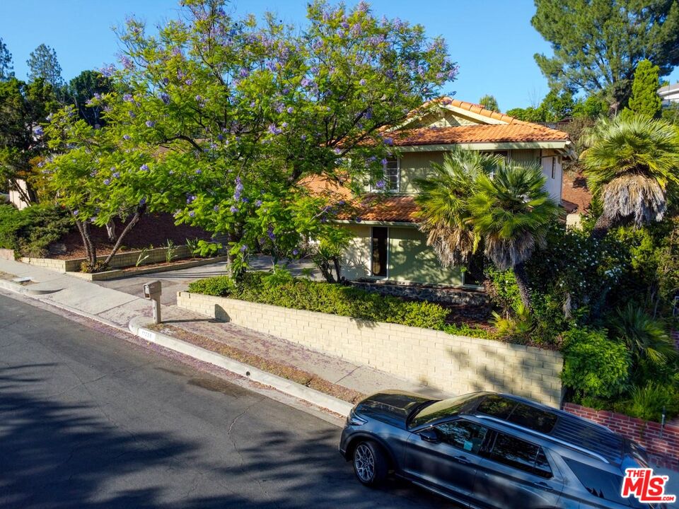 11258 Yolanda Avenue Porter Ranch, CA 91326 - Photo 11 of 46 a backyard of a house with table and chairs under an umbrella