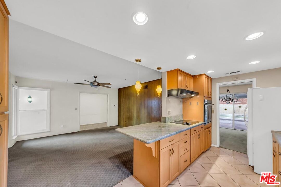 11258 Yolanda Avenue Porter Ranch, CA 91326 - Photo 17 of 46 a kitchen with granite countertop a sink a refrigerator and a stove