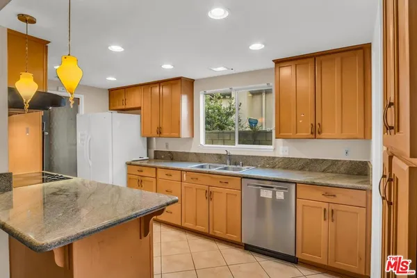 a kitchen with a sink a center island and cabinets