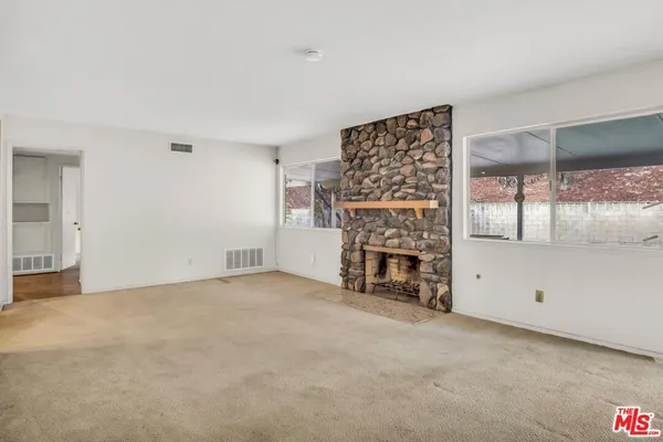an empty room with a fireplace and painted walls
