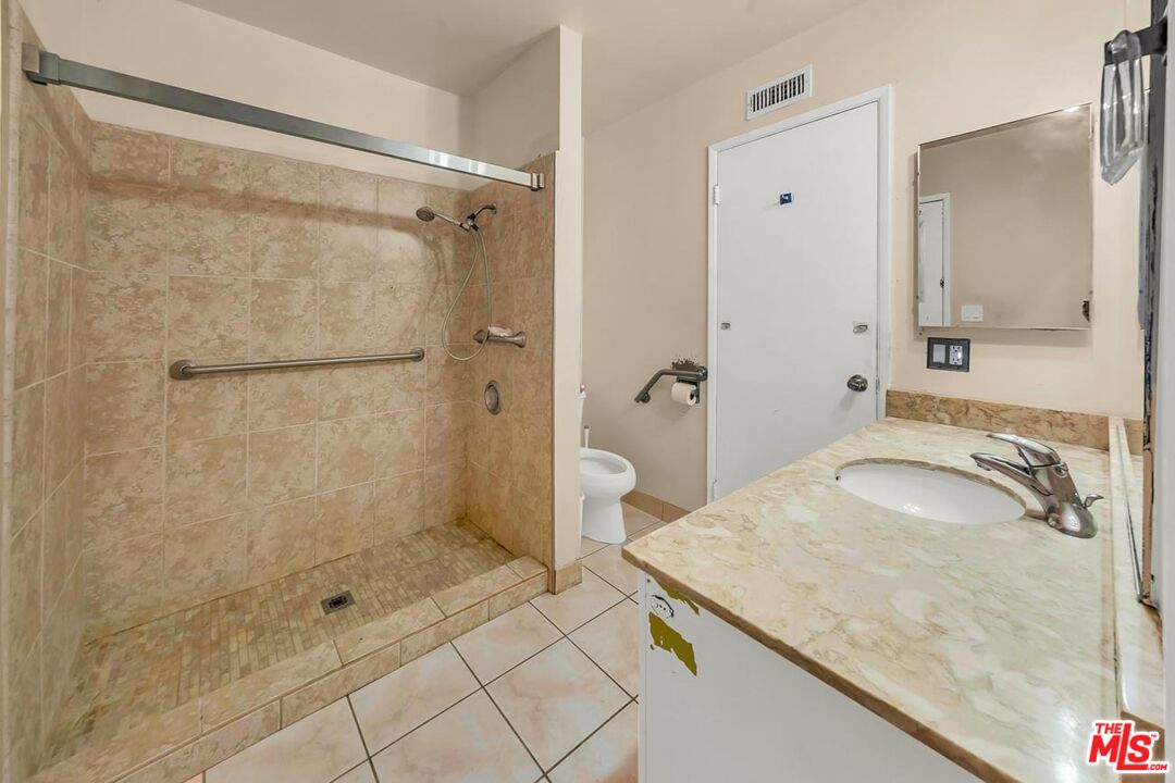 11258 Yolanda Avenue Porter Ranch, CA 91326 - Photo 39 of 46 a bathroom with a granite countertop sink a shower and mirror