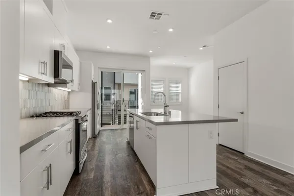 a kitchen with granite countertop white cabinets and white appliances
