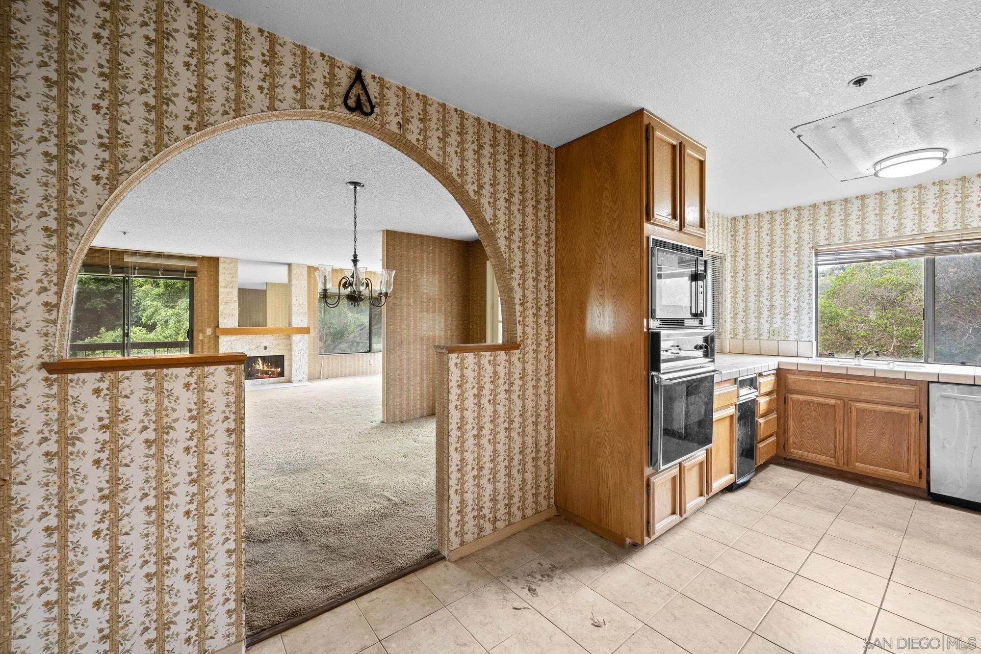 5665 Friars Road, Unit 232 San Diego, CA 92110 - Photo 17 of 30 a view of a kitchen with a sink and dishwasher a refrigerator with wooden floor