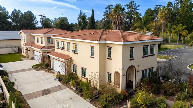 a aerial view of a house with a yard plants and large tree