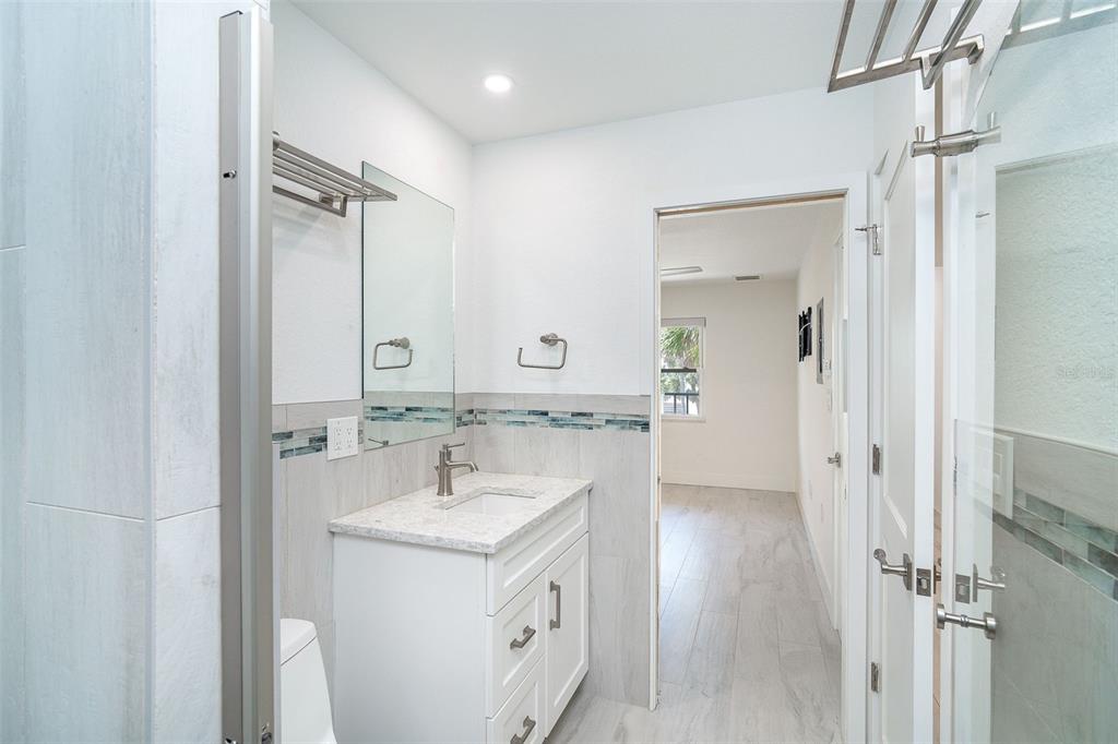 2700 North Beach Road, Unit A201 Englewood, FL 34223 - Photo 15 of 55 a bathroom with a double vanity sink a mirror and a shower