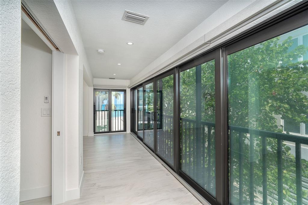 2700 North Beach Road, Unit A201 Englewood, FL 34223 - Photo 23 of 55 a view of hallway with a large window and wooden floor