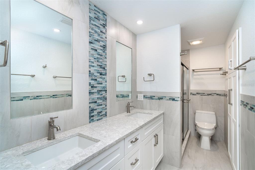 2700 North Beach Road, Unit A201 Englewood, FL 34223 - Photo 30 of 55 a spacious bathroom with a granite countertop sink a toilet and shower