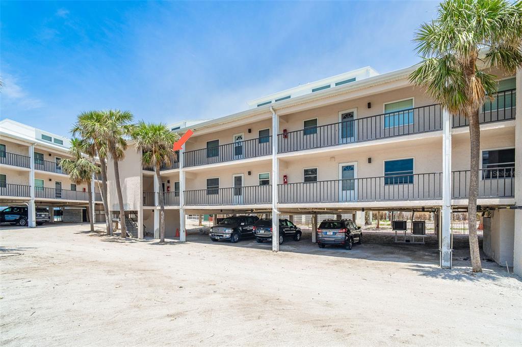 2700 North Beach Road, Unit A201 Englewood, FL 34223 - Photo 3 of 55 a large building with a lot of cars parked