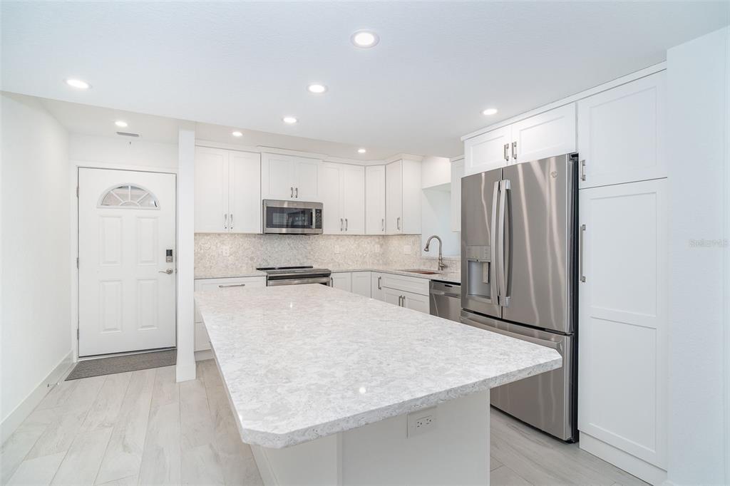 2700 North Beach Road, Unit A201 Englewood, FL 34223 - Photo 5 of 55 a kitchen with stainless steel appliances granite countertop a refrigerator and a stove top oven