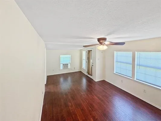 a view of a livingroom with wooden floor and a ceiling fan