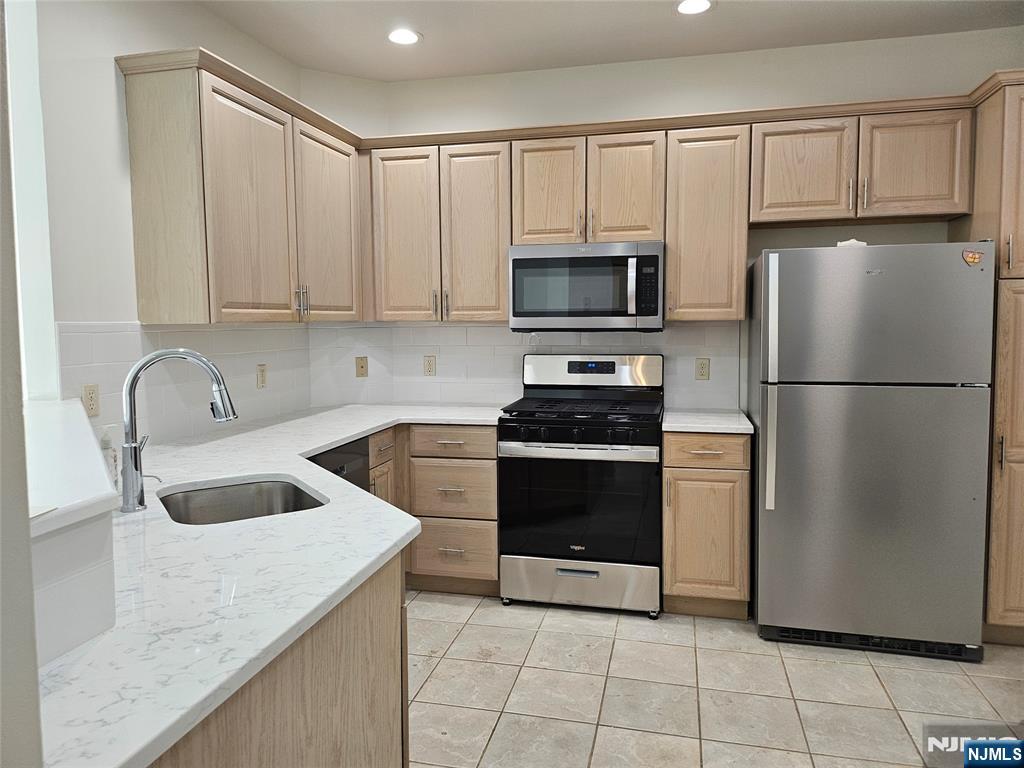 80 Ridgewood Road, Unit 212 Tenafly, NJ 07670 - Photo 4 of 14 a kitchen with granite countertop a refrigerator and a sink