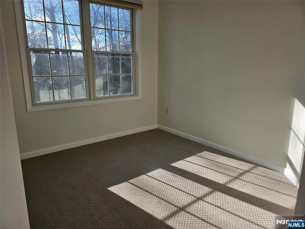 80 Ridgewood Road, Unit 212 Tenafly, NJ 07670 - Photo 8 of 14 a bed sitting in a bedroom next to a window
