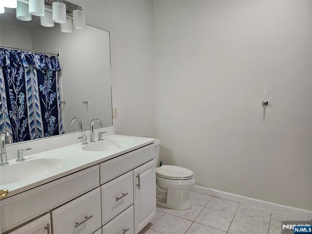 80 Ridgewood Road, Unit 212 Tenafly, NJ 07670 - Photo 9 of 14 a bathroom with a sink toilet and vanity