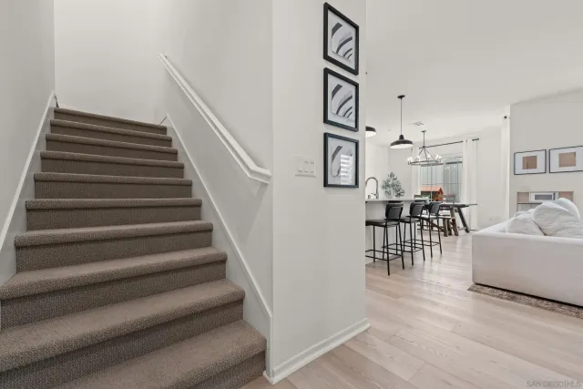 a living room with furniture and a dining table with wooden floor