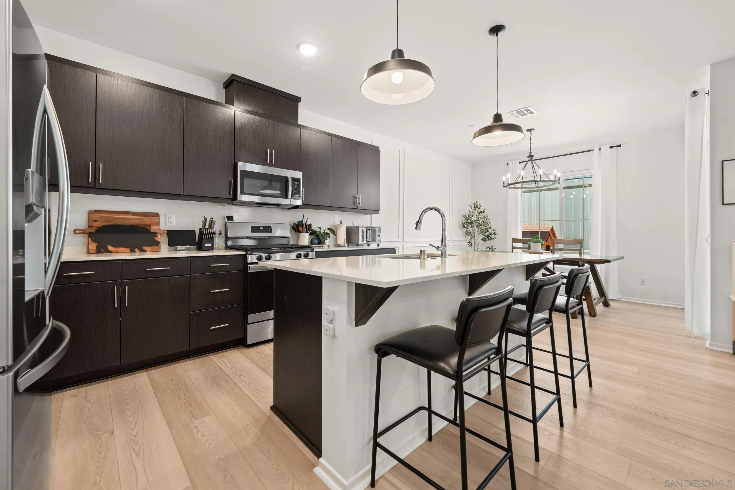 232 Perennial Place Fallbrook, CA 92028 - Photo 6 of 49 a kitchen with stainless steel appliances a sink a stove a refrigerator cabinets and a dining table