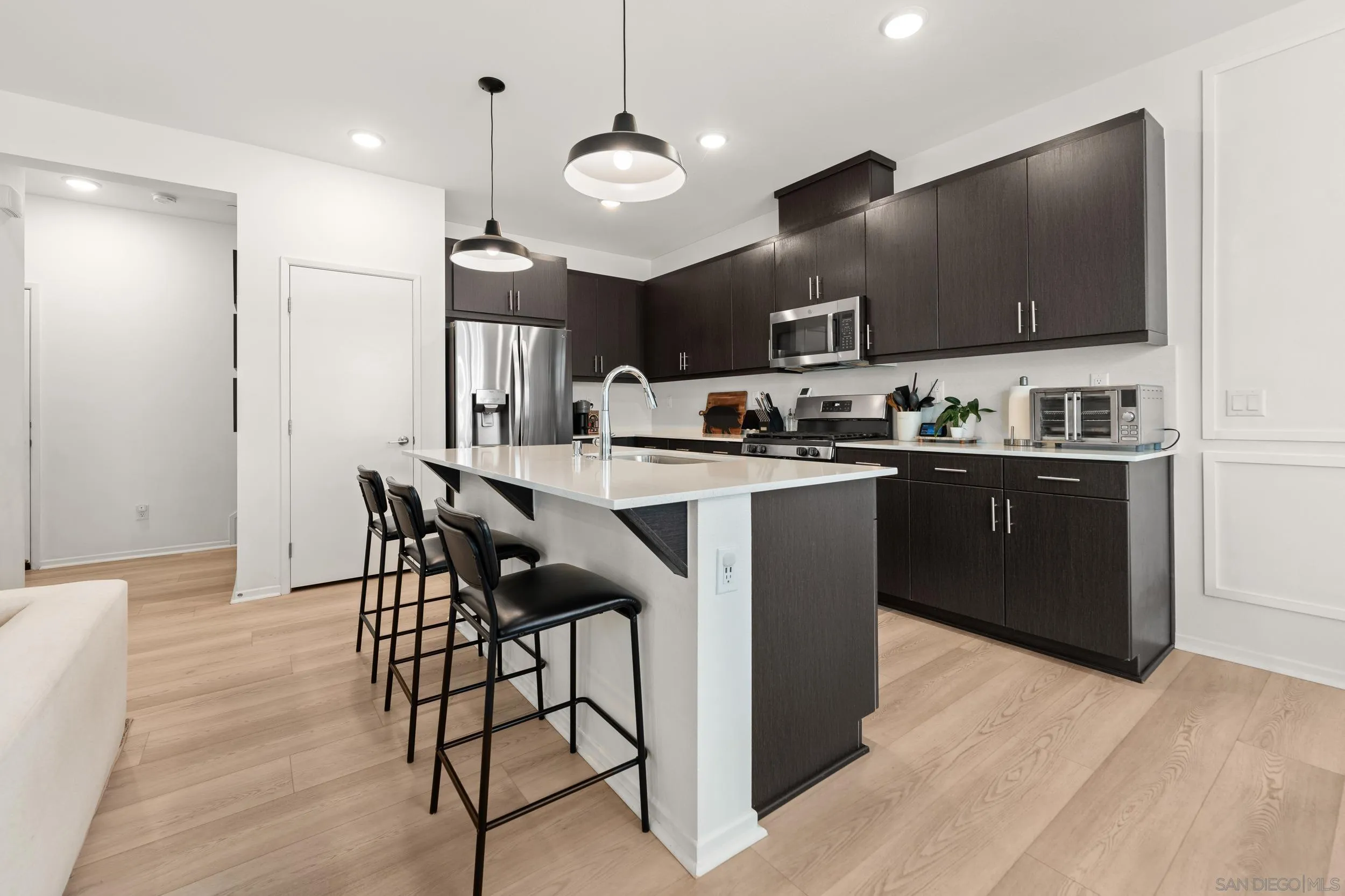 232 Perennial Place Fallbrook, CA 92028 - Photo 10 of 49 a kitchen with stainless steel appliances kitchen island granite countertop a sink a stove a dining table and chairs
