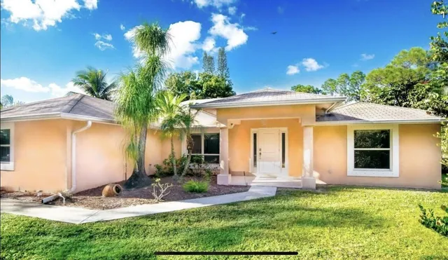 a view of a house with backyard and sitting area