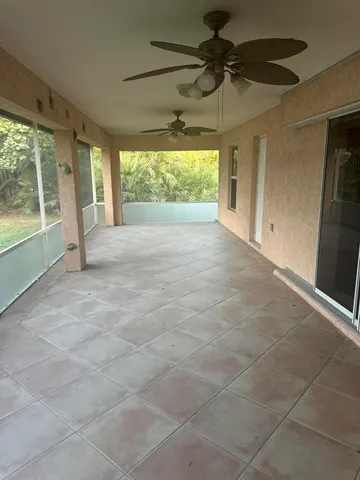 a view of empty room with a floor to ceiling window and a ceiling fan