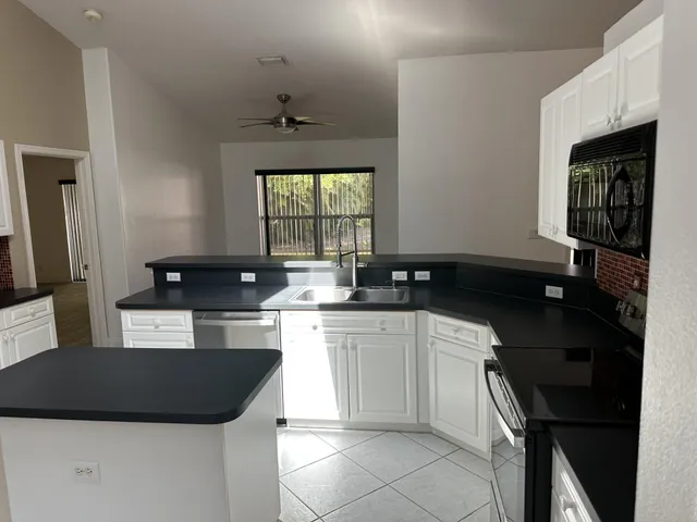 a kitchen with a sink a stove and cabinets