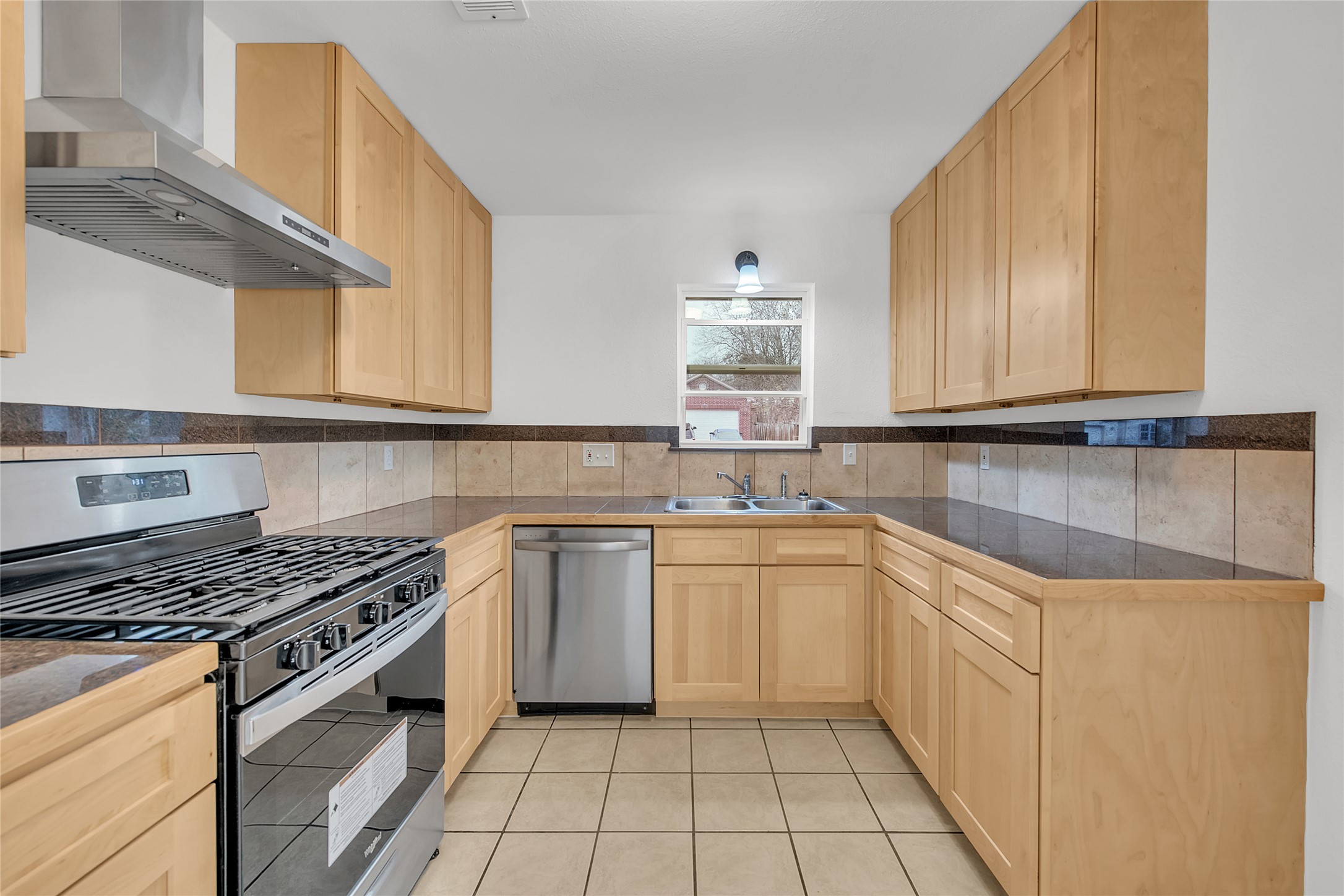 7209 Gunnison Pass Austin, TX 78724 - Photo 6 of 19 Well-equipped kitchen features ample wood cabinetry, sleek countertops, and a modern stainless steel appliance suite.