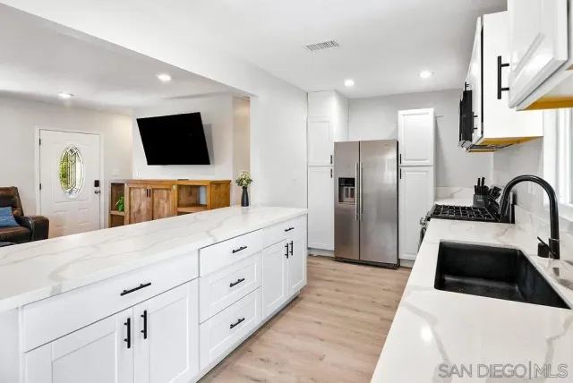 a kitchen with stainless steel appliances a refrigerator sink and microwave