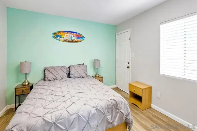 a bedroom with a bed and a painting on the wall