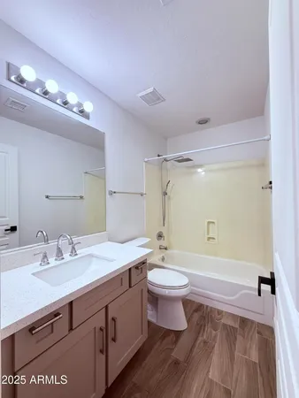 a bathroom with a double vanity sink a toilet a mirror and shower