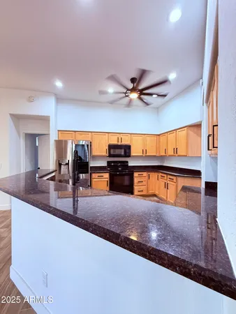 a kitchen with stainless steel appliances granite countertop a sink and a view of living room
