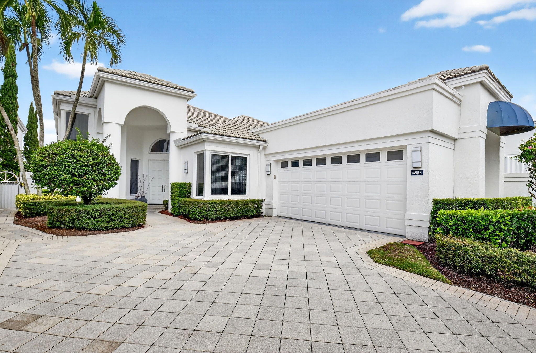 2563 Northwest 63rd Street Boca Raton, FL 33496 - Photo 3 of 65 a front view of a house with garden