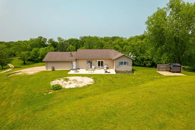 an aerial view of a house with a yard and large trees