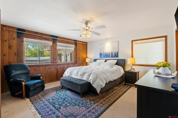 a spacious bedroom with a bed a couch and dresser