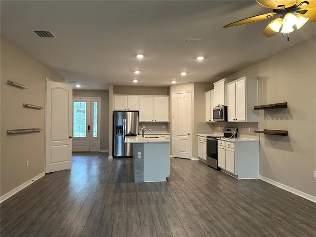 a kitchen with a refrigerator and a stove top oven