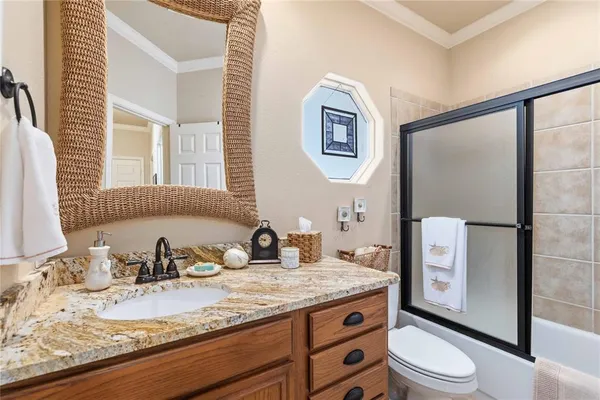 a bedroom with a bed a chandelier and a dresser