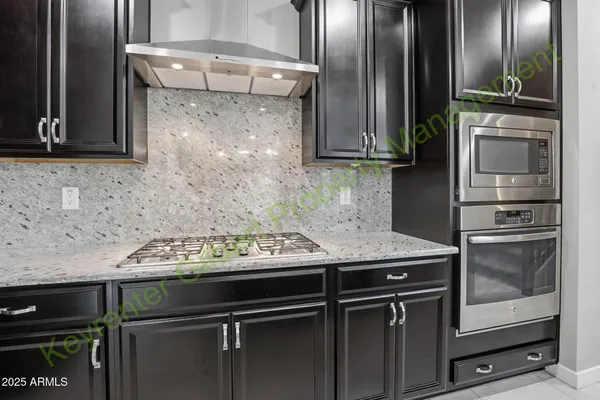 a large kitchen with stainless steel appliances kitchen island granite countertop a large counter top a refrigerator and cabinets