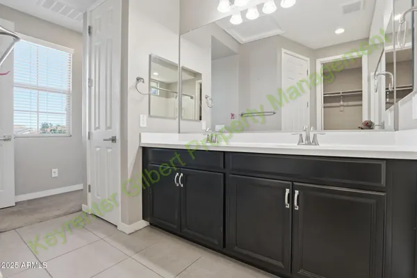 an empty room with windows and chandelier fan