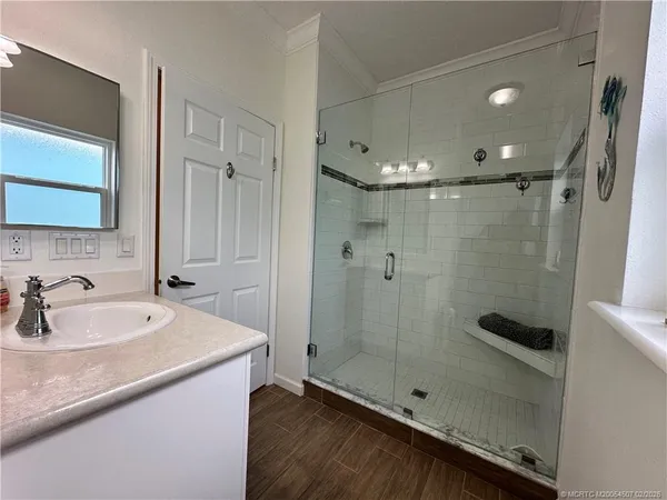 a bathroom with a shower sink and mirror