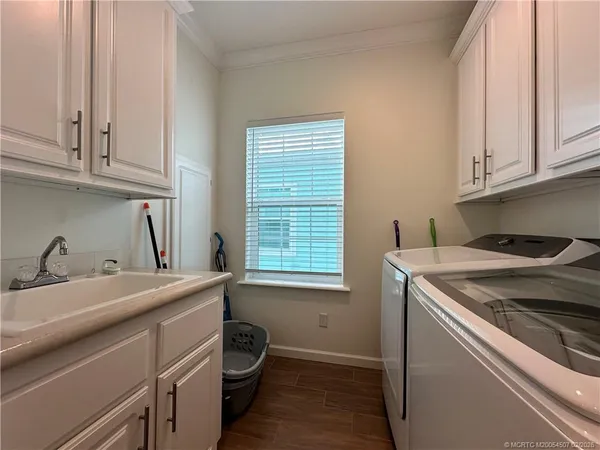 a utility room with sink dryer and washer