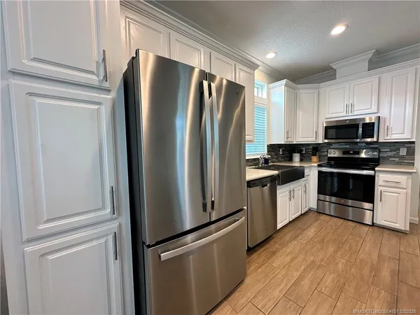 a kitchen with granite countertop stainless steel appliances and refrigerator