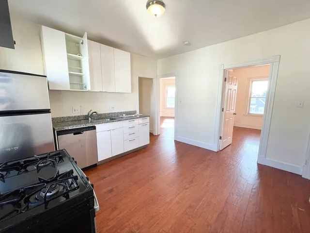 a kitchen with a stove wooden floor and a refrigerator