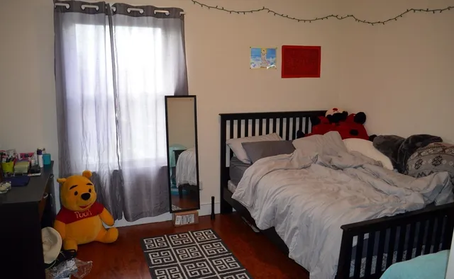 a bed sitting in a bedroom next to a window