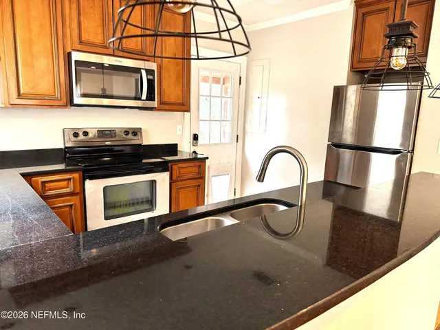 a kitchen with stainless steel appliances granite countertop a stove and a microwave