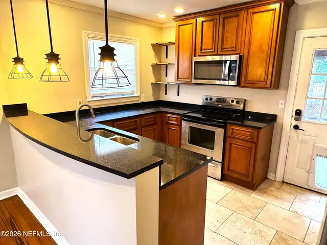 a kitchen with stainless steel appliances granite countertop a sink and a stove