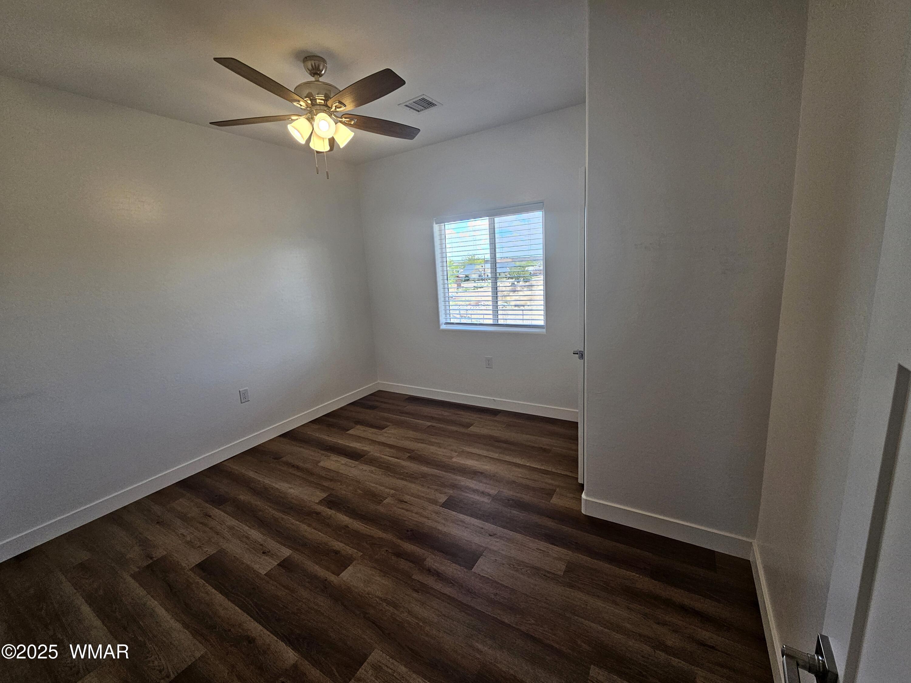 759 South 5th W Street Snowflake, AZ 85937 - Photo 16 of 18 a view of an empty room with wooden floor and a window