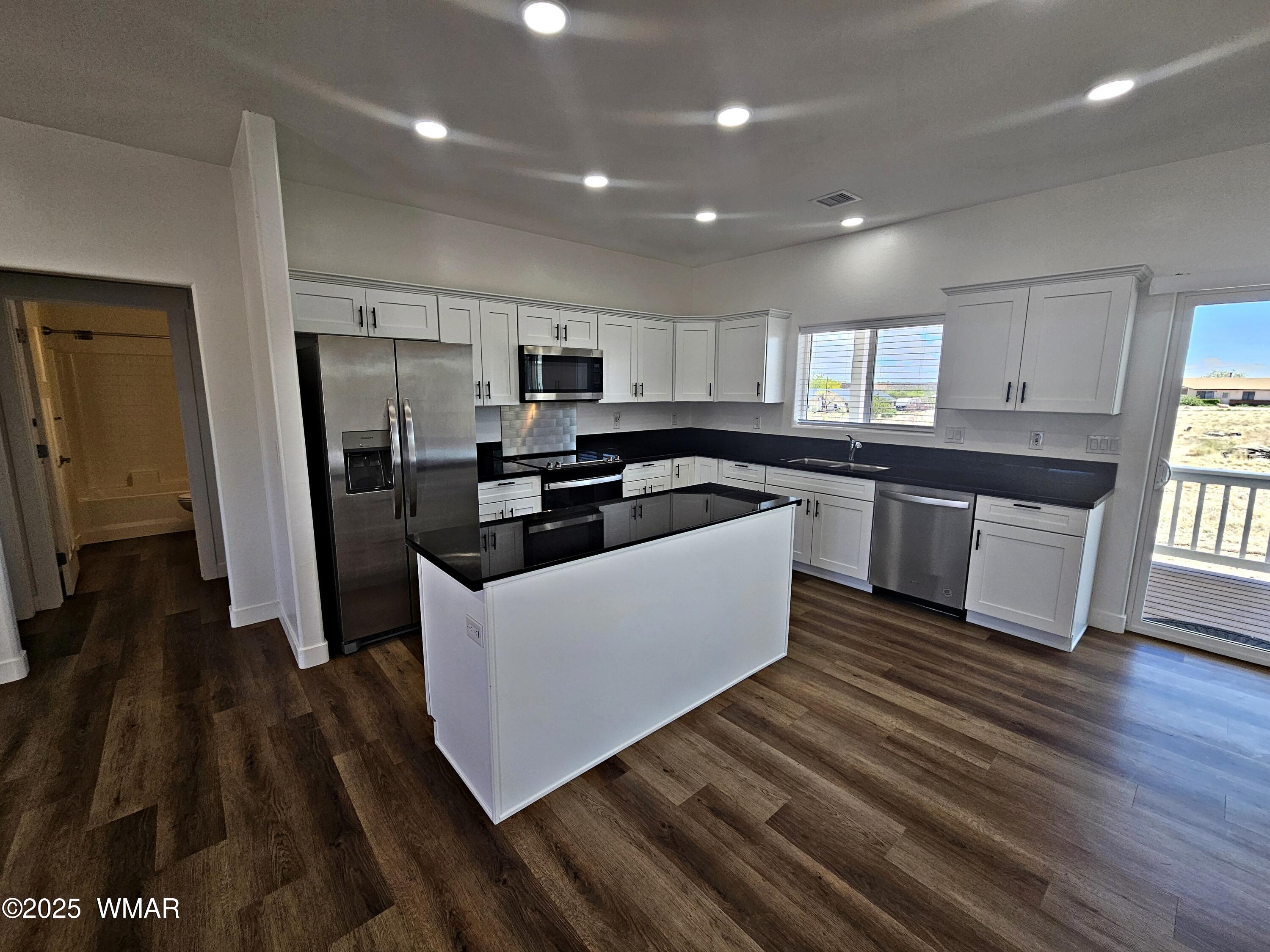 759 South 5th W Street Snowflake, AZ 85937 - Photo 8 of 18 a kitchen with stainless steel appliances a refrigerator a sink a stove a microwave and wooden floors