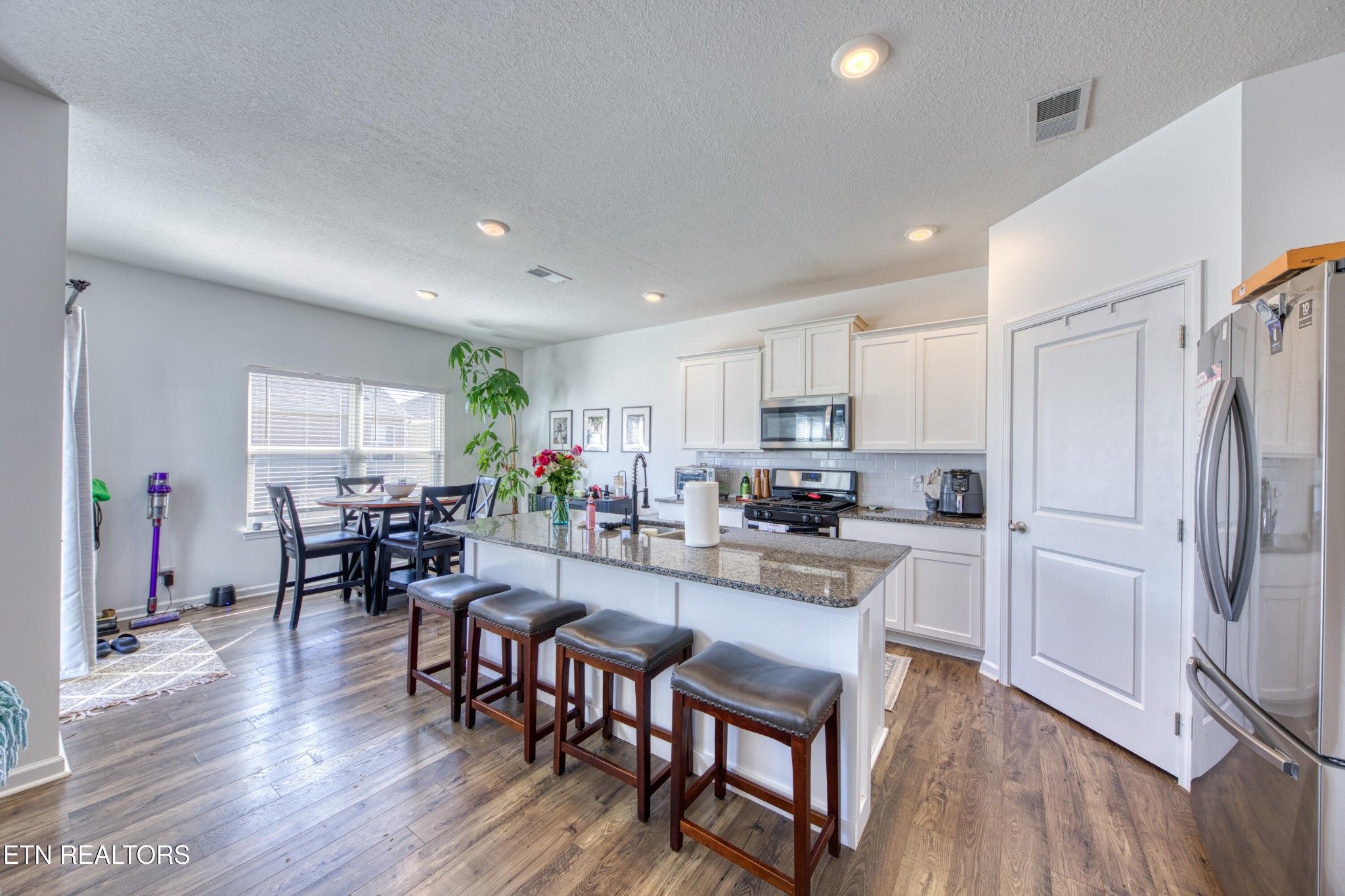 155 Ibis Loop Oak Ridge, TN 37830 - Photo 6 of 20 a kitchen with a dining table chairs refrigerator and cabinets