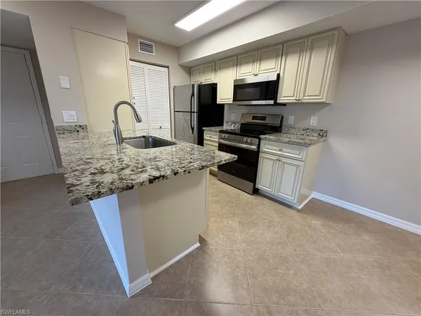 a kitchen with stainless steel appliances granite countertop a sink stove and microwave
